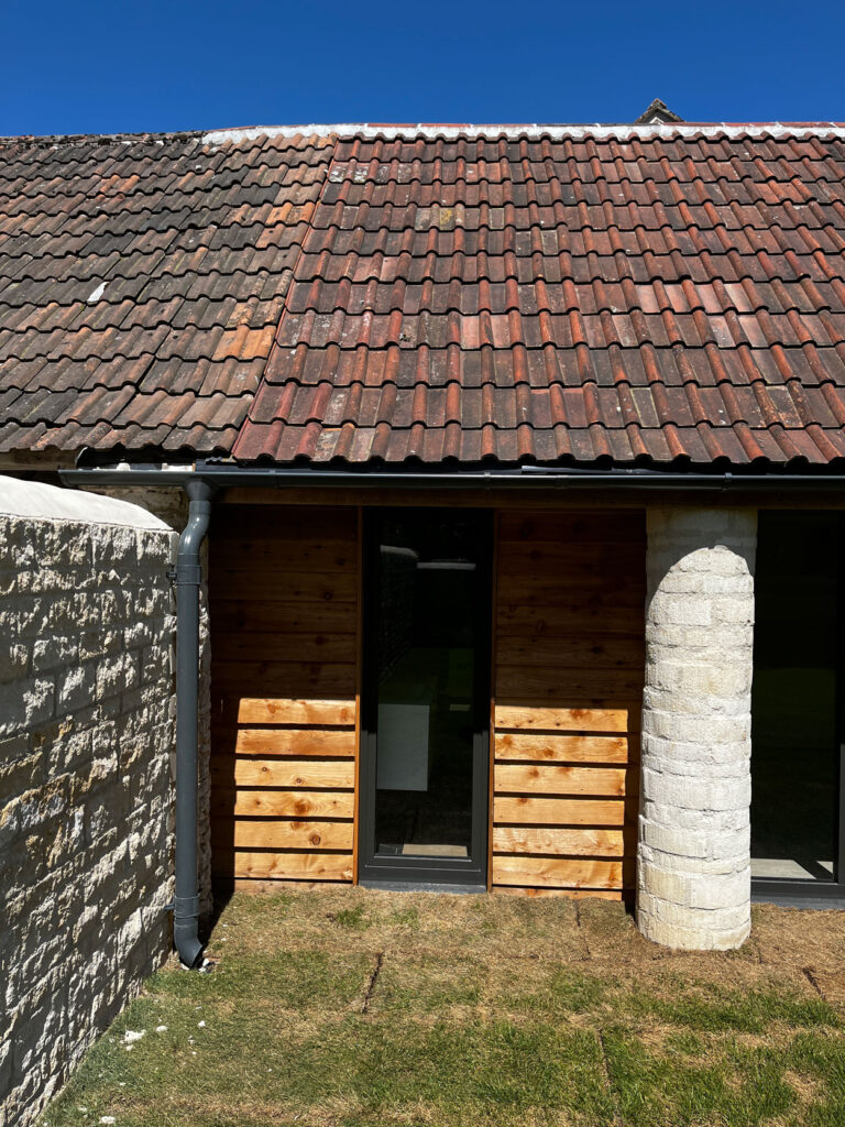 Exterior view of a barn conversion wth a pillar at The Farmyard in Grittleton, Wiltshire