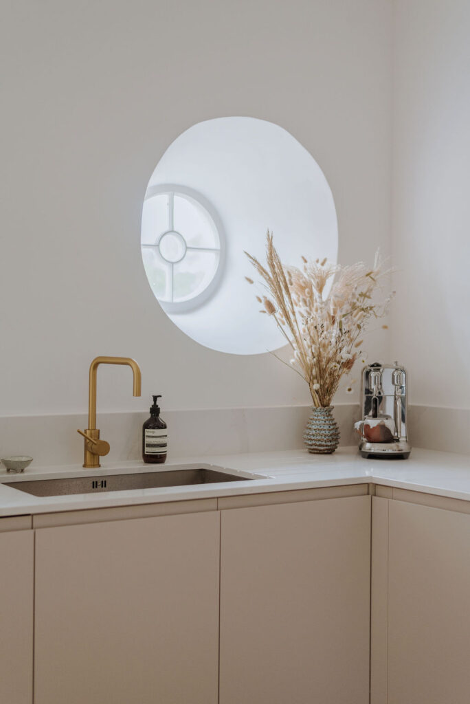 Kitchen sink below a round windown at The Priory in Tetbury, Cotswolds